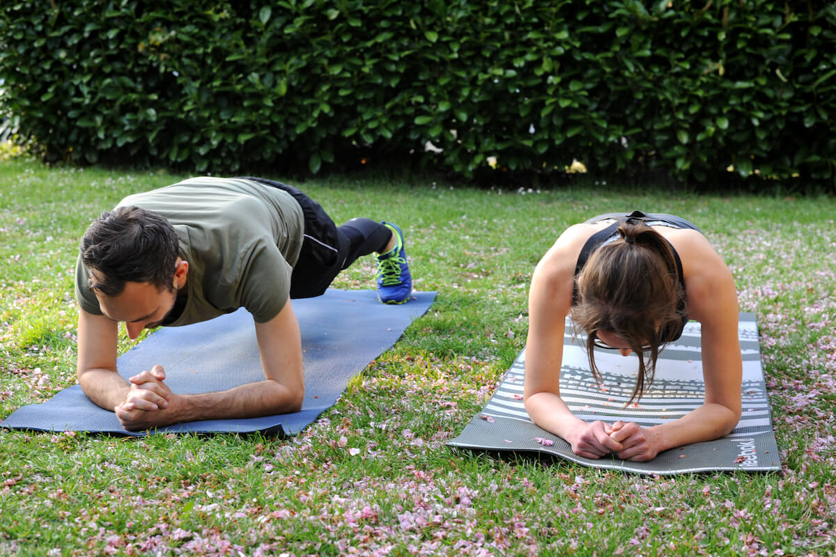 A personal trainer and a client performing a plank exercise